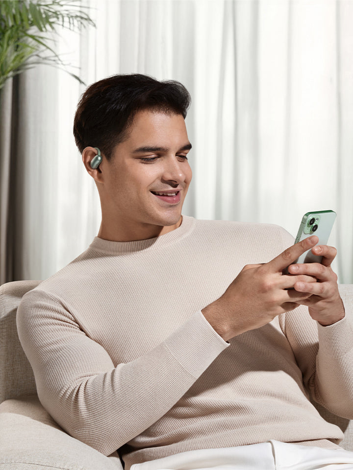 A man using his phones with his earbuds.