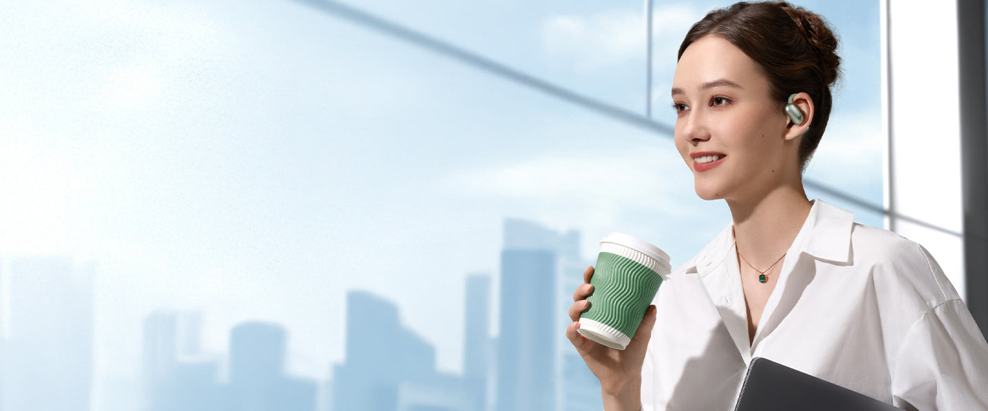 A woman holding a cup wearing green earbuds.